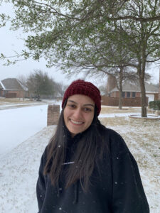 Picture of Elisha, one of the podcast hosts, smiling in front of a snowy landscape